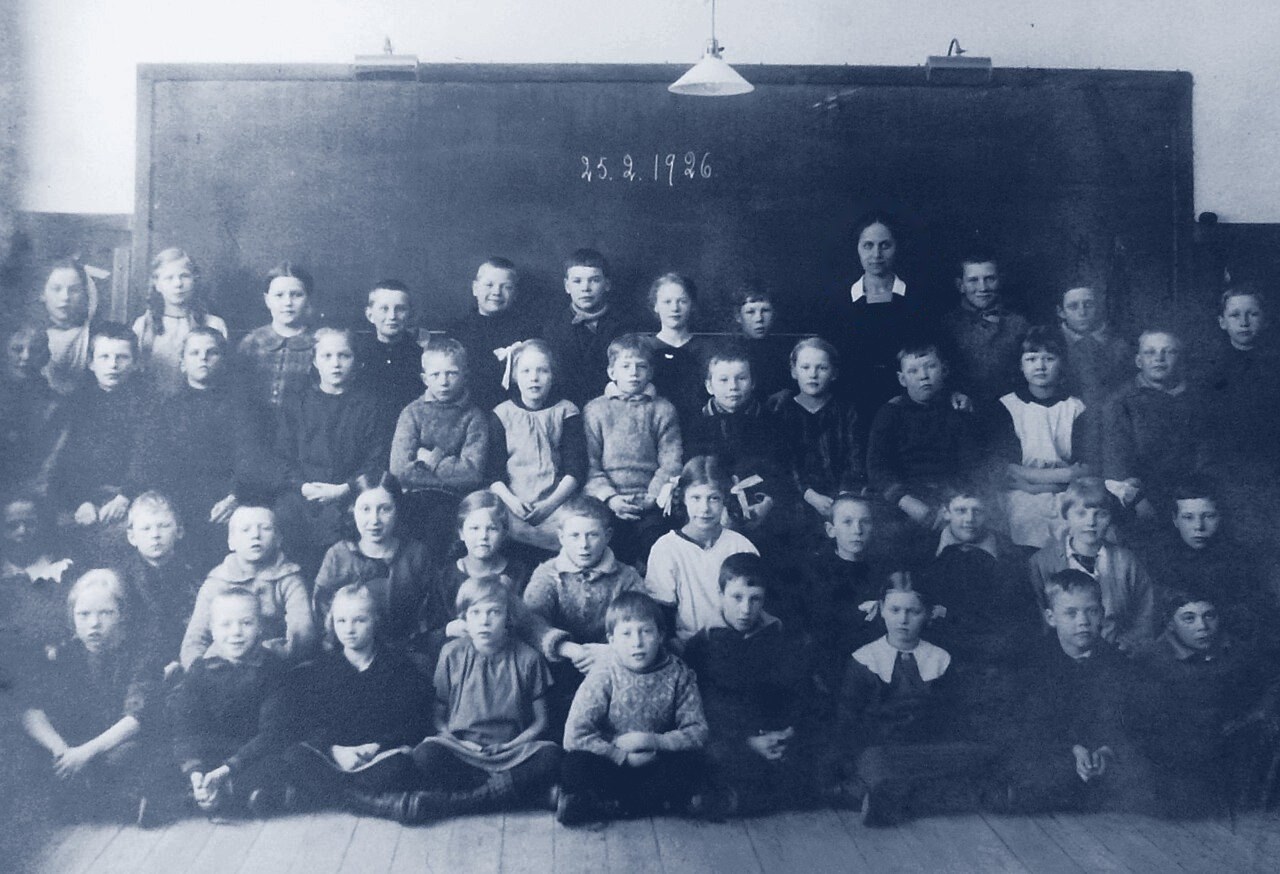 Klassfoto från Segeltorpsskolan 1926. Lärarinnan längst bak ringas in.